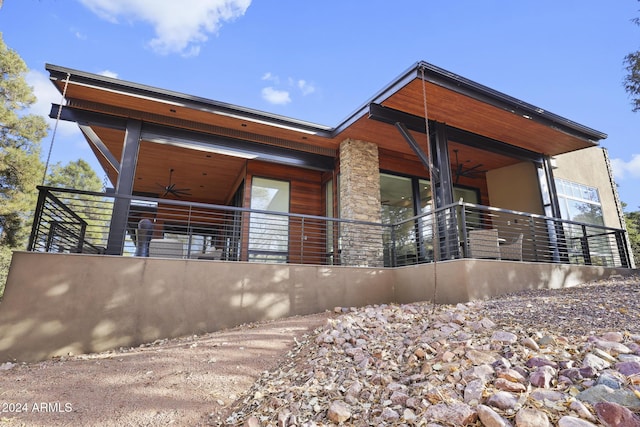 rear view of property featuring ceiling fan