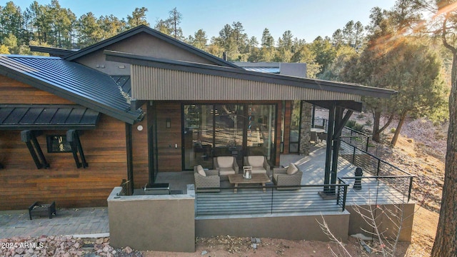 rear view of property featuring an outdoor living space and a patio area