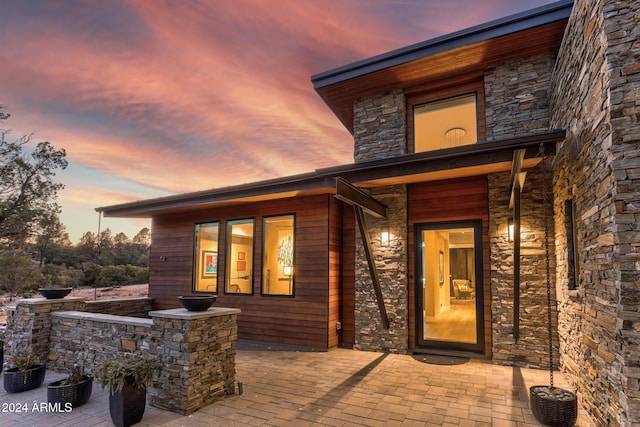 exterior entry at dusk with a patio