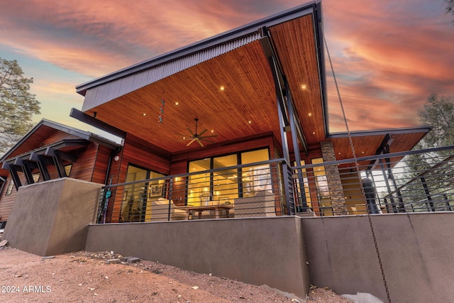 property exterior at dusk featuring ceiling fan