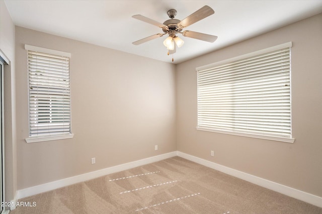 spare room with baseboards, a ceiling fan, and light colored carpet