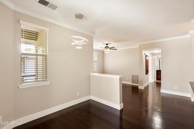 empty room with plenty of natural light, dark wood finished floors, and visible vents