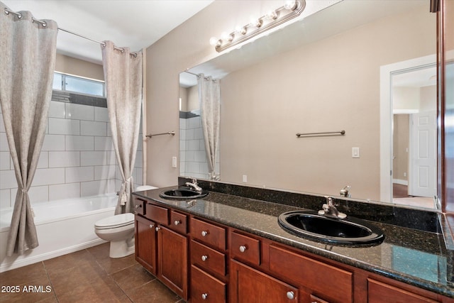 bathroom with double vanity, tile patterned flooring, toilet, and a sink