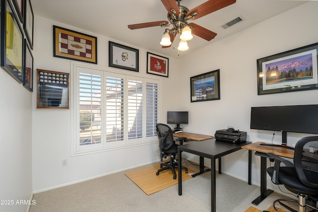 carpeted office space featuring ceiling fan