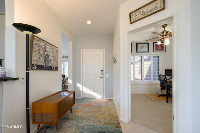 entryway featuring ceiling fan and light colored carpet