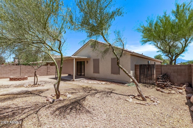 330 S Valley Dr, Apache Junction, AZ 85120 - back of property featuring a fenced backyard, stucco siding, an outdoor fire pit, and a patio