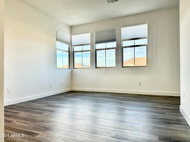 unfurnished room with dark wood-type flooring and a healthy amount of sunlight