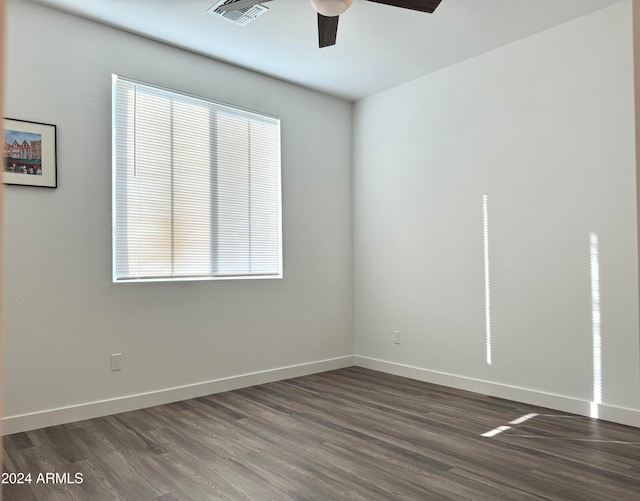 unfurnished room featuring plenty of natural light, dark hardwood / wood-style floors, and ceiling fan