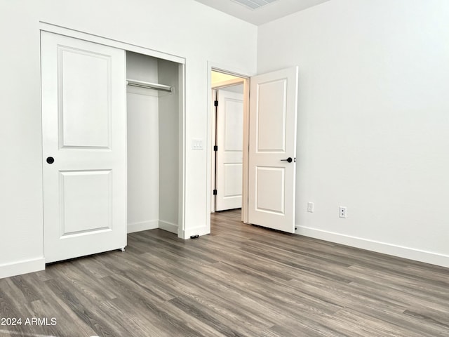 unfurnished bedroom featuring a closet and dark hardwood / wood-style floors