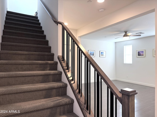 stairs featuring hardwood / wood-style flooring and ceiling fan