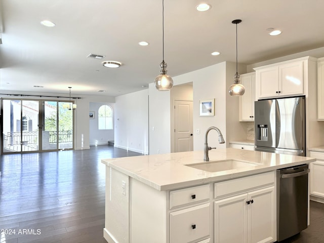 kitchen featuring stainless steel appliances, light stone counters, sink, an island with sink, and white cabinetry