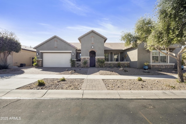 view of front of home featuring a garage, stone siding, decorative driveway, and stucco siding