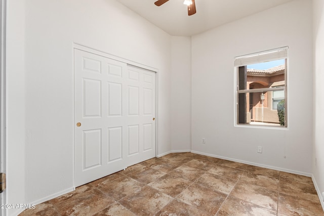 unfurnished bedroom featuring ceiling fan and a closet