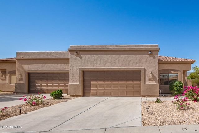 pueblo-style house featuring a garage