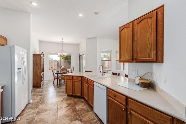 kitchen with pendant lighting, a chandelier, sink, kitchen peninsula, and white appliances