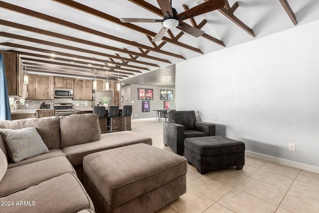 living room with ceiling fan, beamed ceiling, light tile patterned floors, and sink