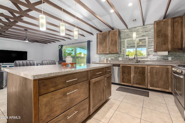 kitchen with pendant lighting, a healthy amount of sunlight, beamed ceiling, and a kitchen island