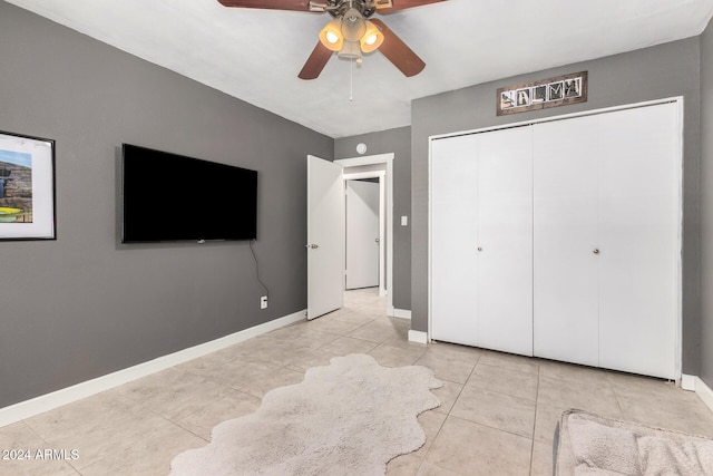 unfurnished bedroom featuring ceiling fan, a closet, and light tile patterned floors