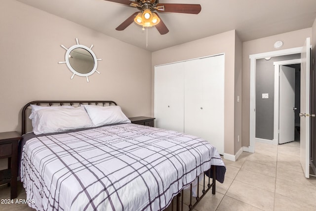 tiled bedroom featuring ceiling fan and a closet