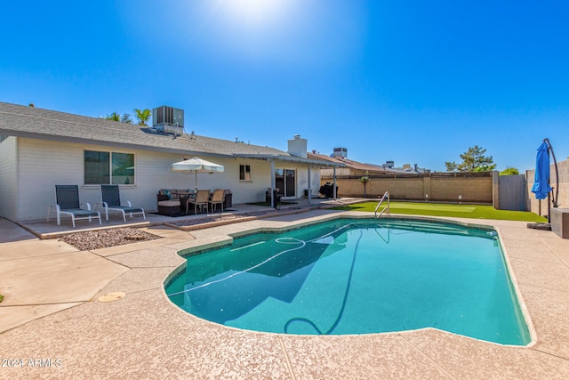 view of pool with cooling unit and a patio area