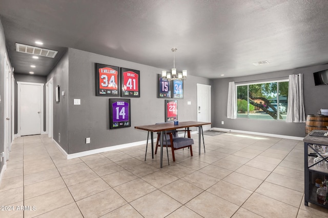 dining space featuring an inviting chandelier, a textured ceiling, and light tile patterned floors