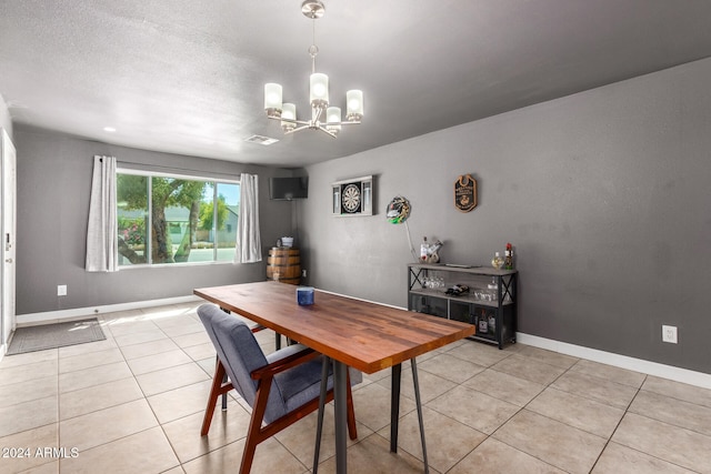 dining area featuring a chandelier, a textured ceiling, and light tile patterned flooring