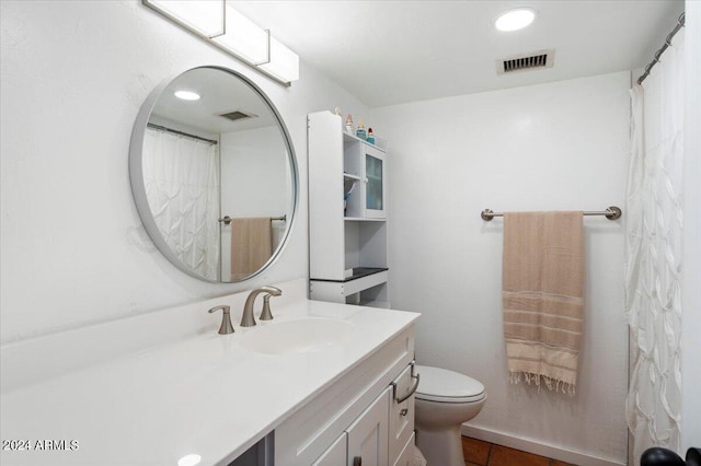 bathroom with vanity, toilet, and tile patterned floors