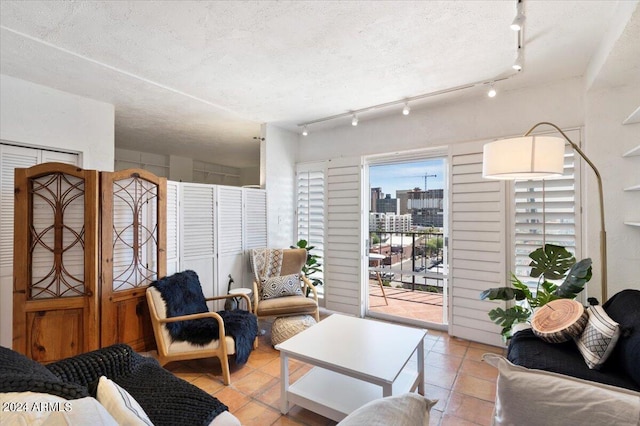 tiled living room with a textured ceiling and rail lighting