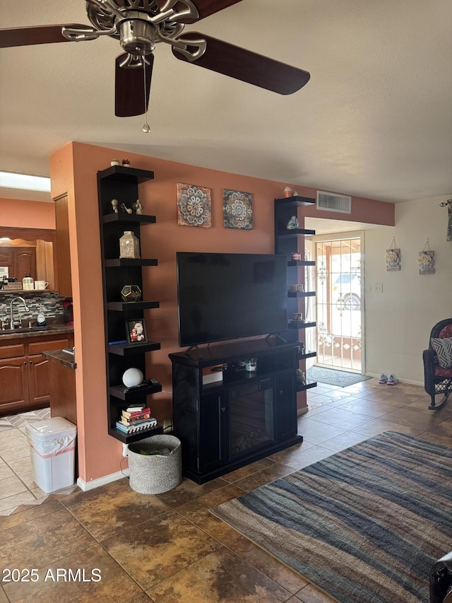living area featuring ceiling fan and visible vents