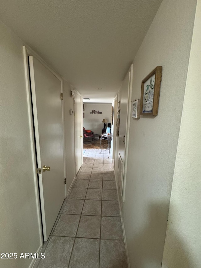 hall with light tile patterned floors