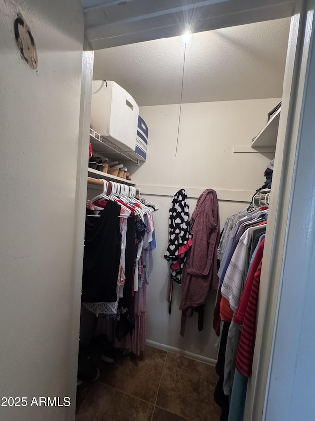 walk in closet featuring dark tile patterned floors