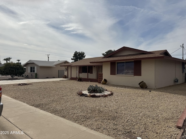 ranch-style home with a garage, concrete driveway, and brick siding