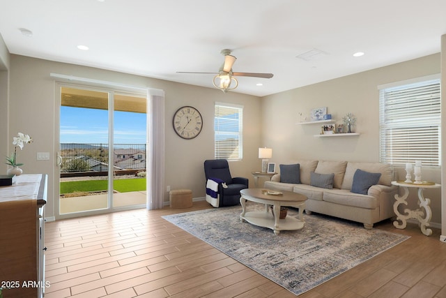 living room with ceiling fan and light wood-type flooring