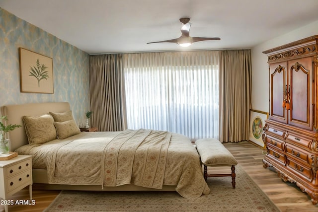 bedroom with light hardwood / wood-style floors and ceiling fan