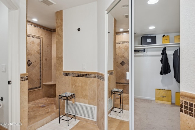 bathroom with tile walls and tiled shower