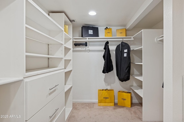 walk in closet featuring light carpet