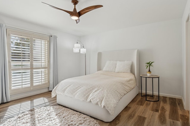 bedroom featuring multiple windows, hardwood / wood-style flooring, and ceiling fan