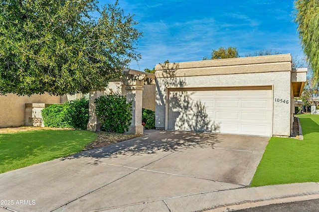 pueblo-style home with a garage and a front lawn