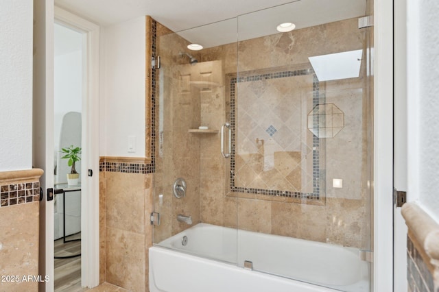 bathroom featuring shower / bath combination with glass door and tile walls