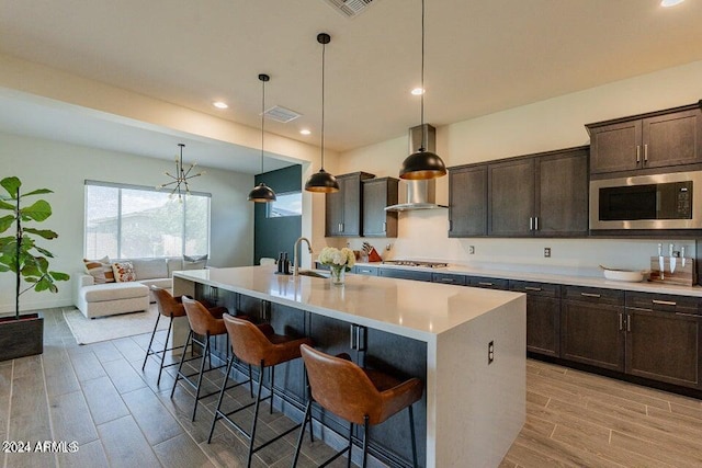 kitchen featuring pendant lighting, light hardwood / wood-style floors, a kitchen breakfast bar, and stainless steel appliances