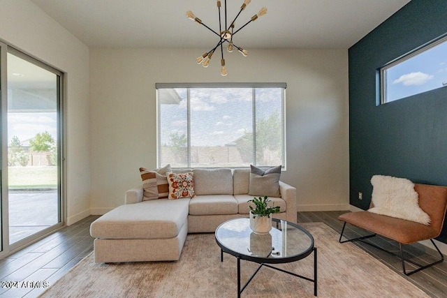 living room featuring a healthy amount of sunlight, an inviting chandelier, and wood-type flooring