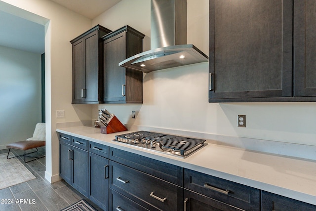 kitchen featuring dark brown cabinets, wall chimney exhaust hood, and stainless steel gas stovetop