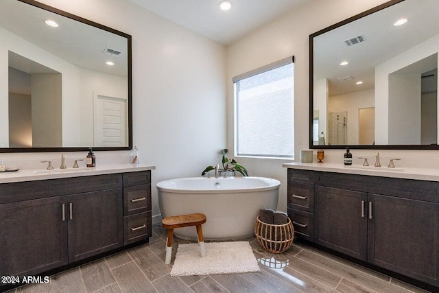 bathroom featuring wood-type flooring, plus walk in shower, and vanity