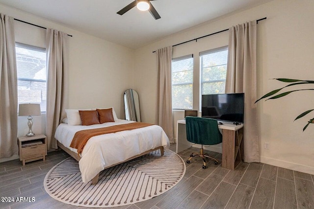 bedroom with dark wood-type flooring, multiple windows, and ceiling fan