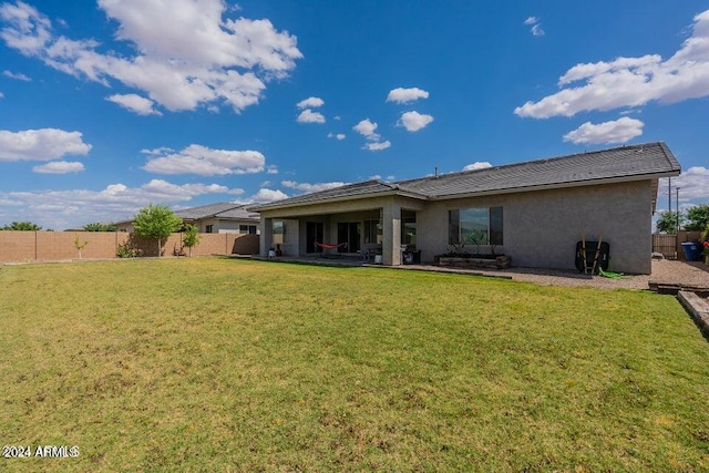 back of house with a yard and a patio area