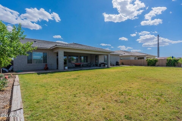 rear view of house featuring a yard and a patio