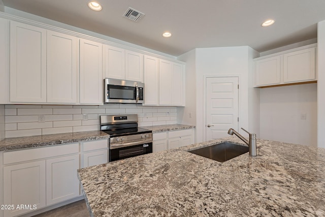 24184 W Gibson Ln, Buckeye, AZ 85326 - kitchen featuring stainless steel appliances, white cabinetry, and recessed lighting