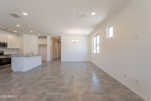 24184 W Gibson Ln, Buckeye, AZ 85326 - kitchen featuring appliances with stainless steel finishes, a chandelier, recessed lighting, white cabinetry, and a kitchen island with sink