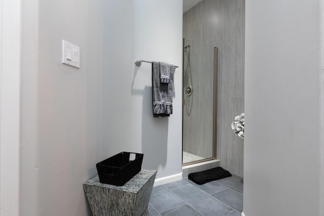 full bathroom featuring tile patterned flooring, a shower stall, and baseboards