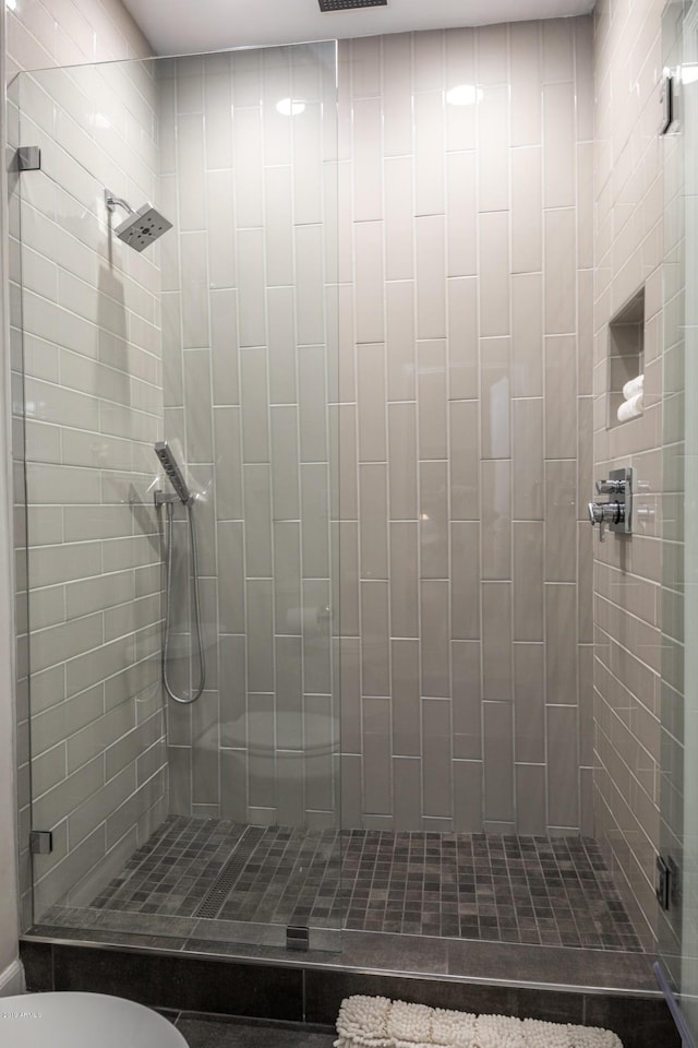 bathroom with a shower stall and toilet